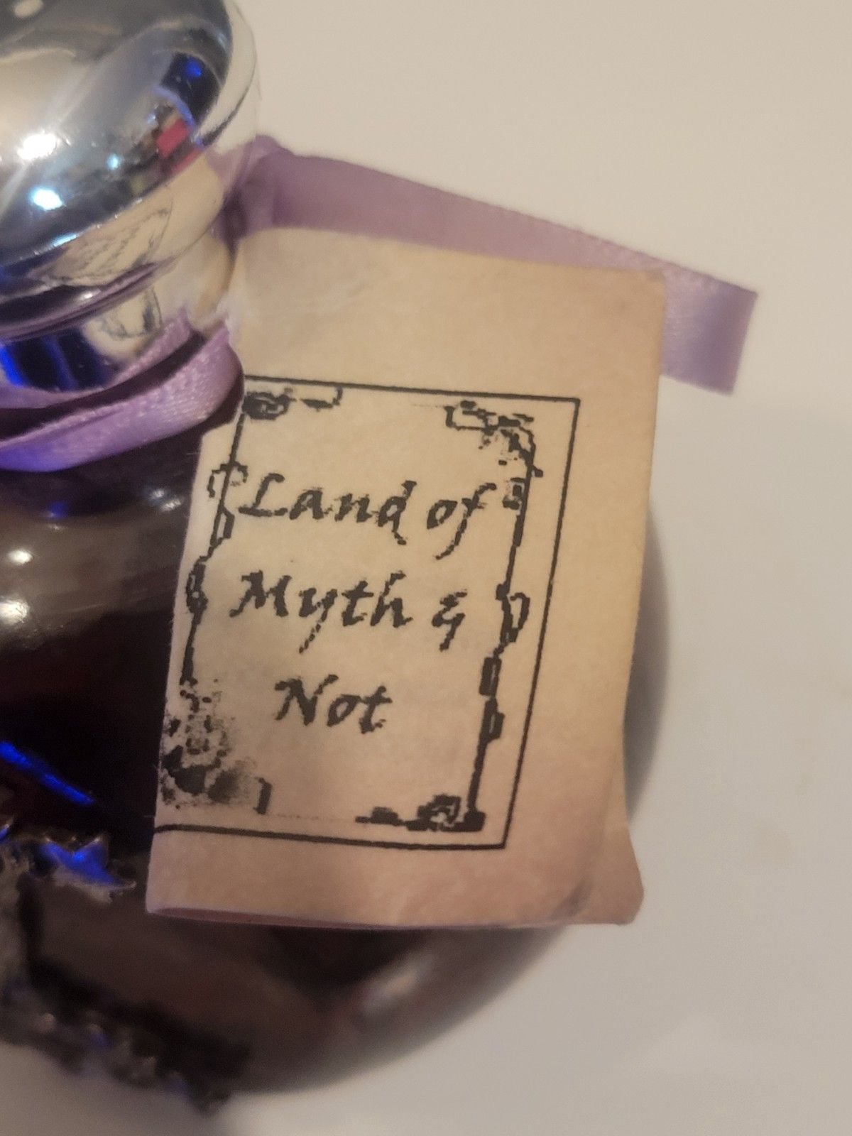 Land of Myth & Not" purple oil candle featuring a pewter fairy on a moon design. 8