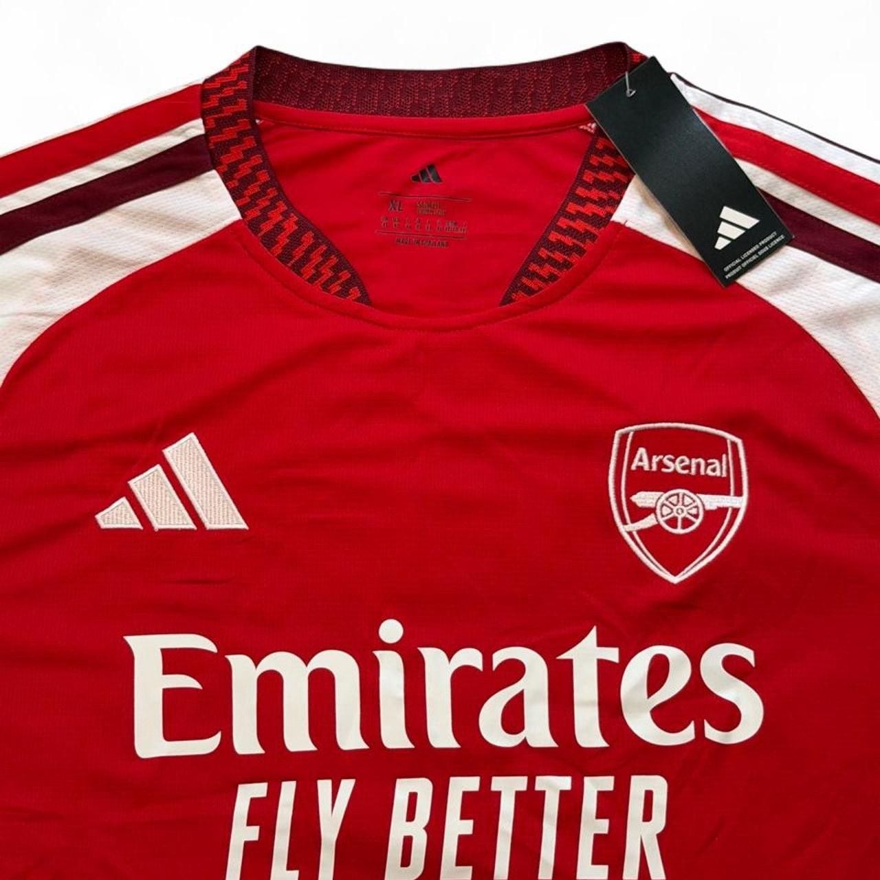 Adidas Arsenal 2026/27 home shirt in red with white sleeves and red stripes number seven Saka on the back size XL dimensions in the pictures brand new with tags. 5