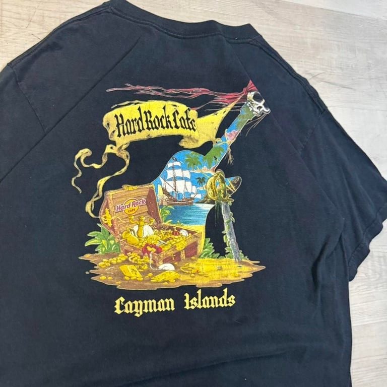 🔥 Vintage Hard Rock Café Cayman Islands Pirate Tee 🔥
🏴☠️ Set sail in style with this dope vintage Hard Rock Café shirt featuring an epic pirate-themed graphic! Treasure chests, swords, and a legendary ship make this a must-have for coll 3