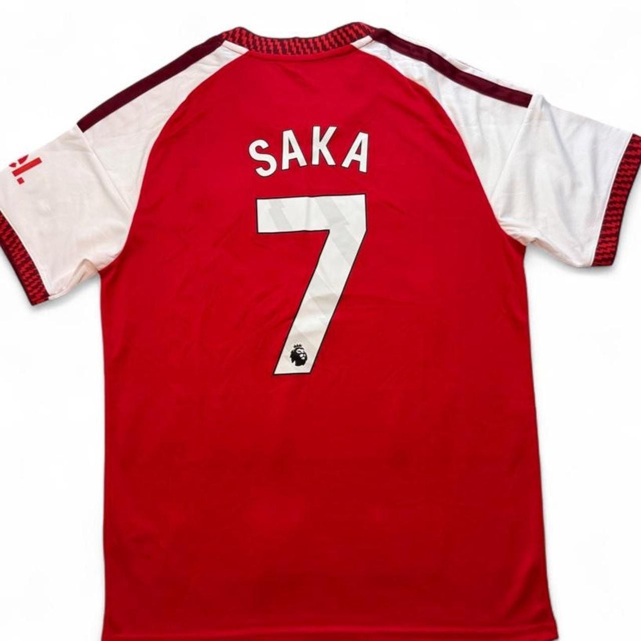 Adidas Arsenal 2026/27 home shirt in red with white sleeves and red stripes number seven Saka on the back size XL dimensions in the pictures brand new with tags. 8