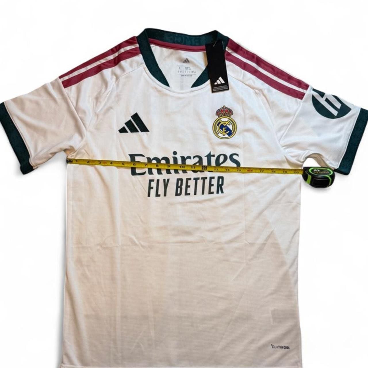 Adidas Real Madrid 2026/27 Home Jersey White with maroon and green stripes on shoulders and sleeves number 5 Bellingham on the back size Large dimensions in the pictures brand new with tags. 4