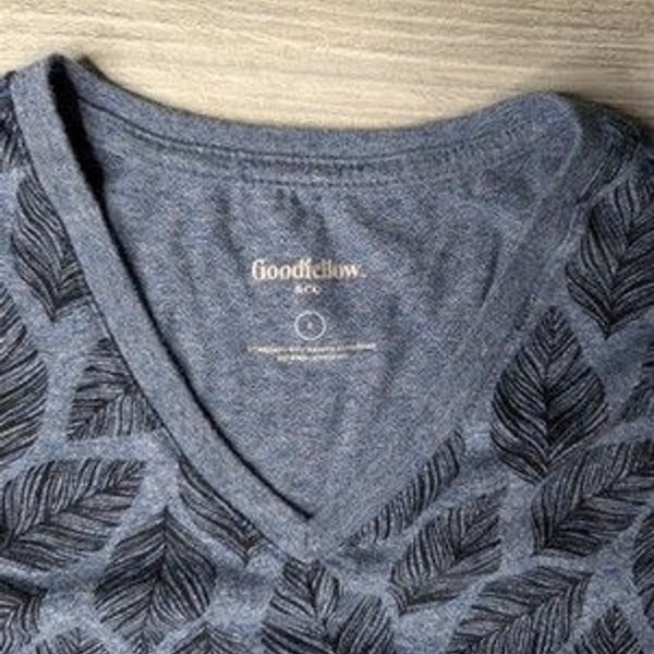 This blue Goodfellow & Co v-neck shirt features a dark leaf pattern.