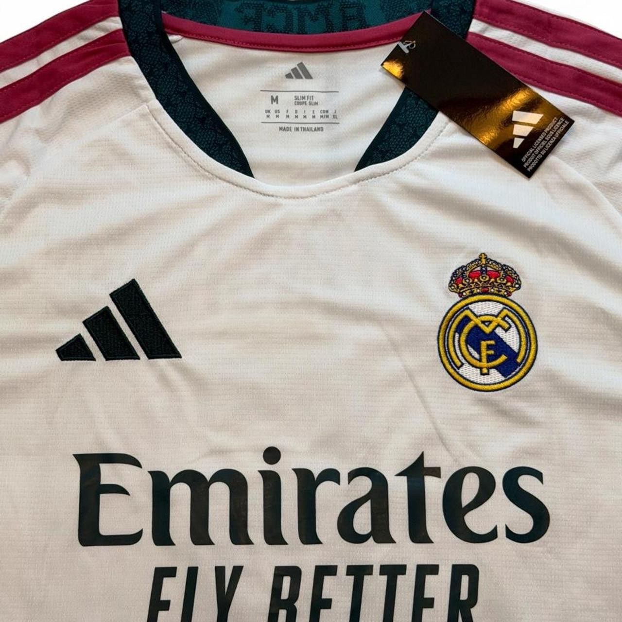 Adidas Real Madrid 2026/27 home shirt in white with maroon and dark green stripes on shoulders and sleeves, number 5 Bellingham on the back size Medium dimensions in the pictures brand new with tags. 5