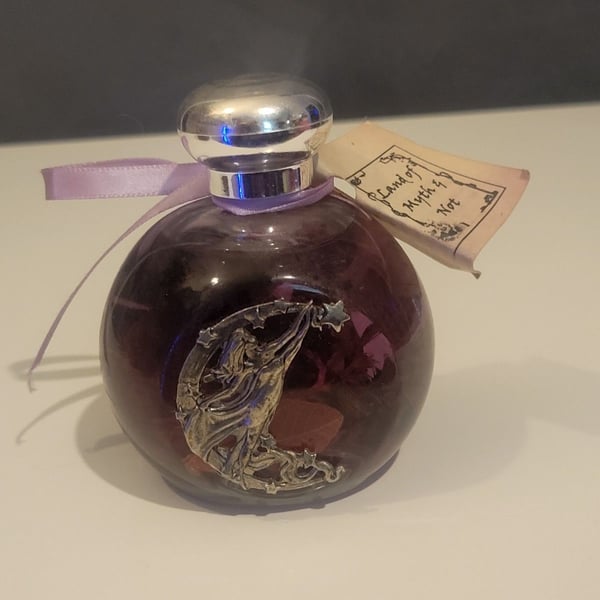Land of Myth & Not" purple oil candle featuring a pewter fairy on a moon design.