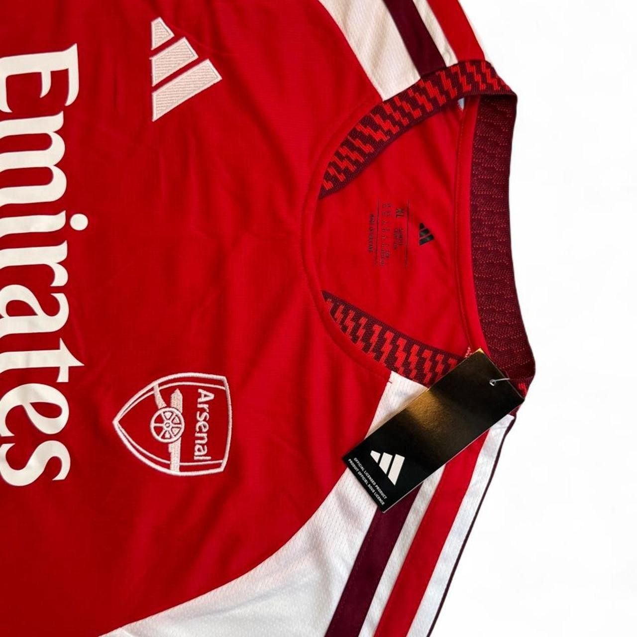 Adidas Arsenal 2026/27 home shirt in red with white sleeves and red stripes number seven Saka on the back size XL dimensions in the pictures brand new with tags. 7