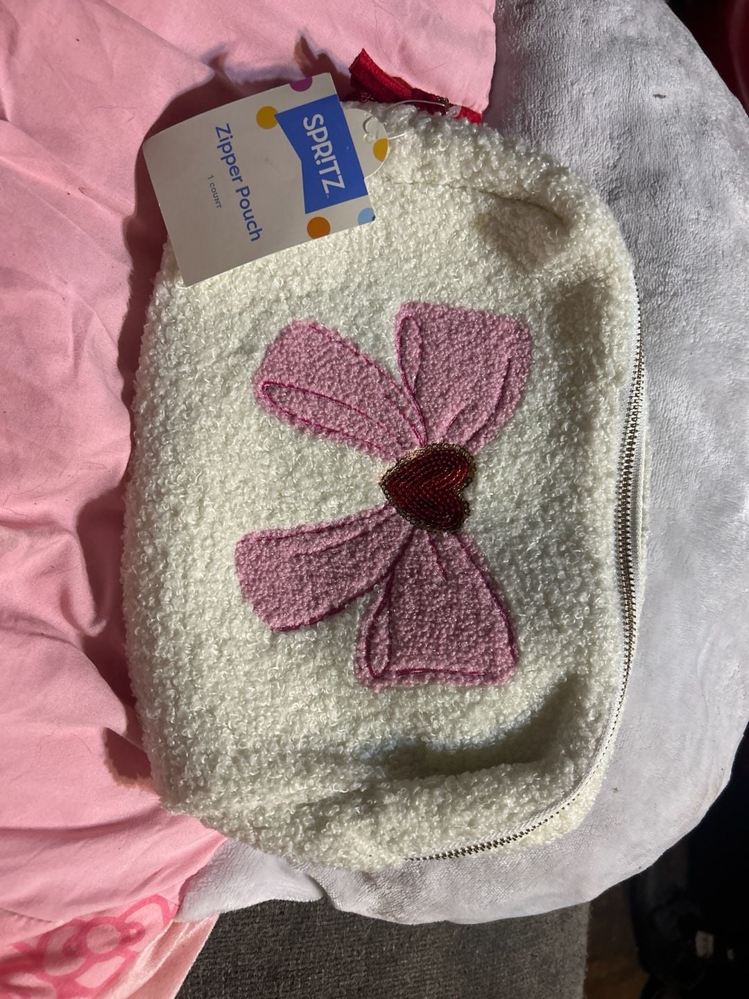White cosmetic bag with a pink bow and a 1