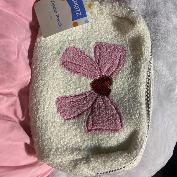 White cosmetic bag with a pink bow and a