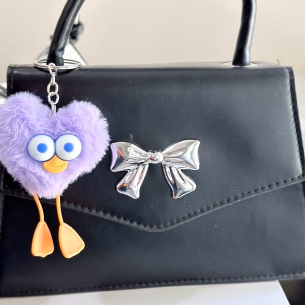 Minimalist Black Mini Square Handbag with Silver Bow Detail and Purple Heart Character Keychain