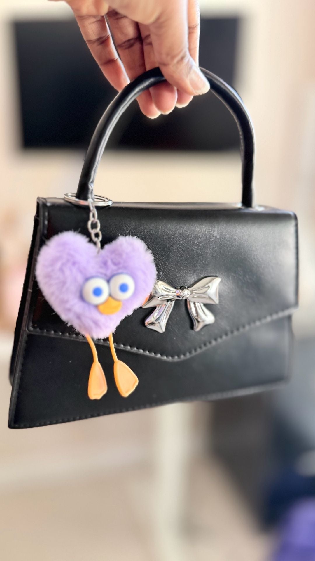 Minimalist Black Mini Square Handbag with Silver Bow Detail and Purple Heart Character Keychain 9