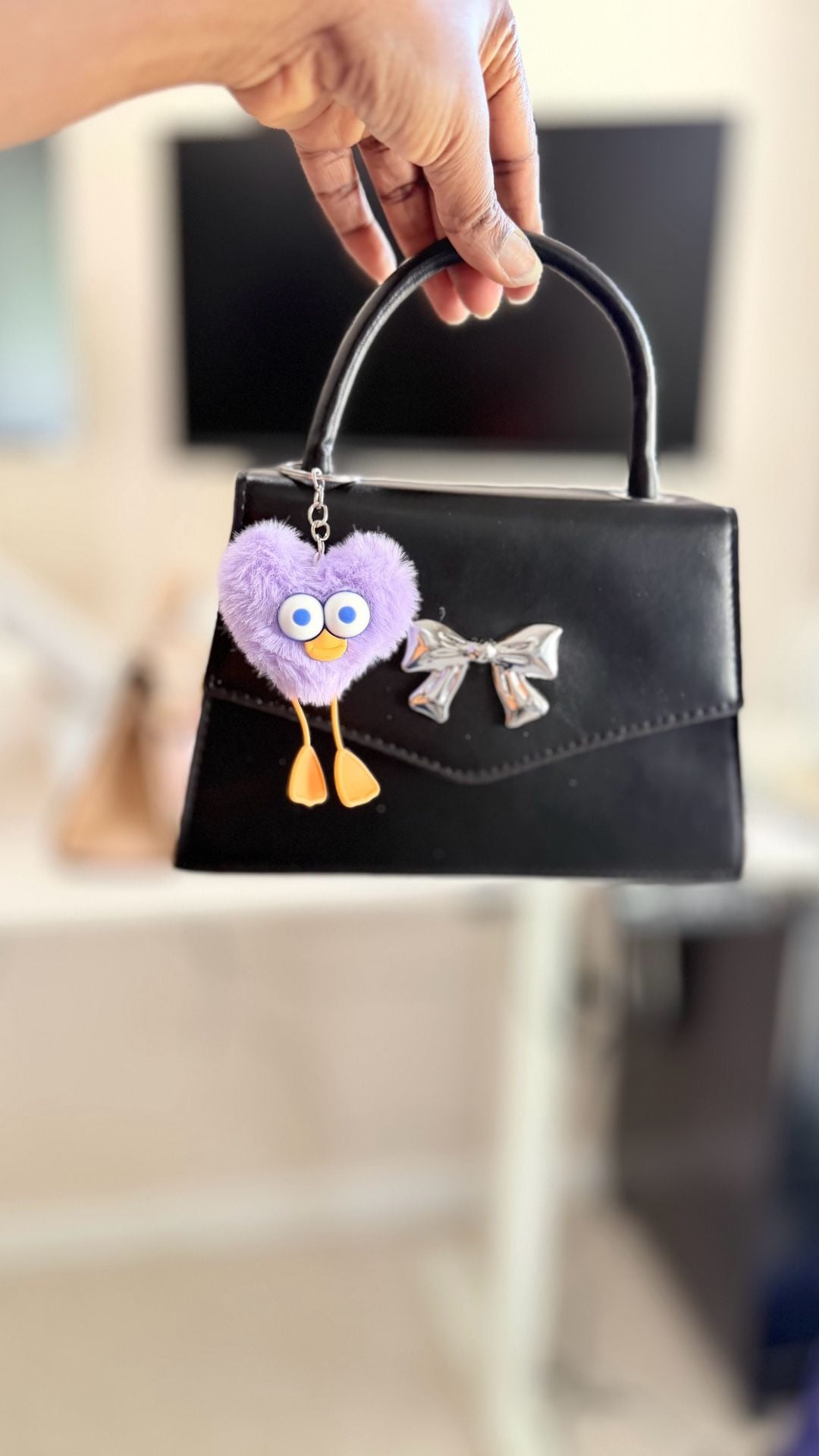 Minimalist Black Mini Square Handbag with Silver Bow Detail and Purple Heart Character Keychain 11