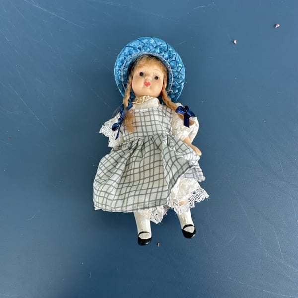 Vintage Miniature Porcelain Doll with Blonde Pigtails, Blue Bonnet, and Checkered Dress