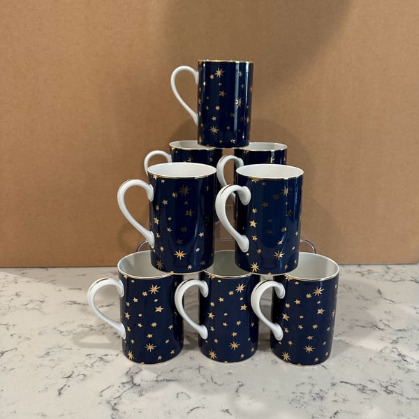 Pre owned, set of 8, Sakura Galaxy Blue porcelain coffee mugs featuring a navy blue celestial star pattern and 14K gold trim, Approximate Size: About 4 1/4 inches tall. Great condition, One of the cups has minimal sign of use, please refer to the photogra