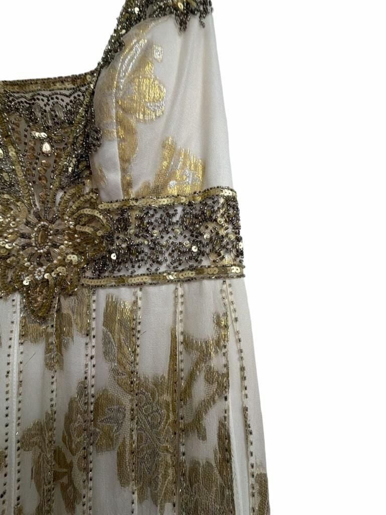 Sue Wong Gold And Cream Empire Waist Gown.
Hand-Applied Embellishments: Individual gowns often feature thousands of hand-stitched beads, sequins, and crystals combined with complex techniques like passementerie and soutache. 
Historical and Vintage Fusion 7