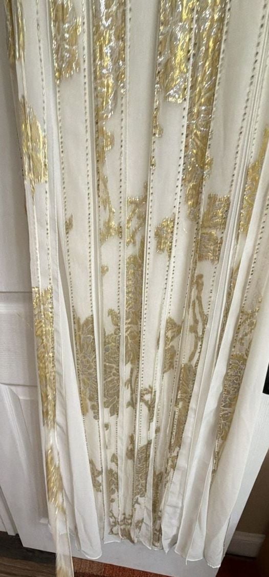 Sue Wong Gold And Cream Empire Waist Gown.
Hand-Applied Embellishments: Individual gowns often feature thousands of hand-stitched beads, sequins, and crystals combined with complex techniques like passementerie and soutache. 
Historical and Vintage Fusion 12