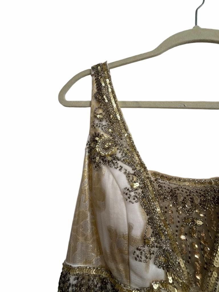 Sue Wong Gold And Cream Empire Waist Gown.
Hand-Applied Embellishments: Individual gowns often feature thousands of hand-stitched beads, sequins, and crystals combined with complex techniques like passementerie and soutache. 
Historical and Vintage Fusion 9